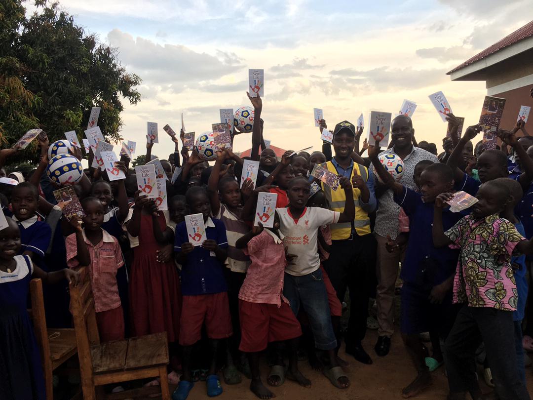 Pupils joyfully celebrating sports items and book donations